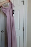 The material feels great! Will need to get it tailored to fit my height but that was expected. Pretty color in person and can't wait to wear it for my friend's wedding! - Stephanie C.