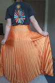 This skirt is absolutely stunning! It also has a wrinkle-resistant quality to it which is EXCELLENT because the pleats are one of my favorite parts about the skirt. The color is vibrant, and exactly as pictured in the photo online (can't speak for the green version). That being said, it is a BIT on the long side. I was hoping to be able to wear flat shoes like sandals with is as summertime is on the way, and this is a perfect spring/summer skirt. It will work fine with heels, but I think if you're going to advertise something as a medium (average), it should fit the average, which is a 5'4" height. As mentioned before though, the movement of the skirt is in-CREDIBLE, and the brightness of the piece is just lovely. So unique. - Kathleen B.