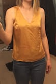 It is a little loose in the stomach area, which I like. So if you wanted form fitting, this isn't it. It fits true to size. It's a little short in the torso area, but that's okay I'll probably wear with high waisted pants. Very silky smooth. - LeeAnn B.