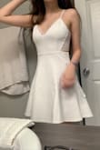 I bought this dress in a size S (followed the size charts!) to wear under my cap and gown for commencement/graduation! It is a BEAUTIFUL dress, and I love the lace back of it! The material is very breathable and comfortable, a bit stretchy and honestly I probably could've sized down to an XS and still fit. I was concerned about the length and if it would squeeze me weird when sitting down. My breasts literally grow a cup in size whenever I'm on my period, so at least with the small I know I'll fit no matter what time of the month haha.

If you are graduating, looking for a bachelorette dress, or just looking for a white mini dress in general, I cannot recommend this item enough! Seriously, just buy it! - Jenny J.