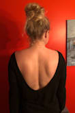 I ordered this sweater in 2 colors (black and camel), and I am so glad! I love how the sexy back is a little bit of surprise compared to the front neckline. I have kind of an athletic build and not the tiniest arms, so I was worried the arms would be snug, but they weren't. I've worn a sticky bra, but it would also be cute with a lacey bralette. Towards the end of the night it does slip off my shoulders a little more, but a little fashion tape would resolve that if it bothered you. I've worn this top several times, including when I got a new back tattoo and it was perfect. :) - Jessica A.