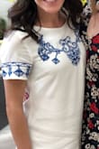I ordered this dress in S and XS for my bridal shower. The S fit fine, but was *slightly* large, so I went with the XS and it fit perfectly! Not too tight in the arms and not too short when I raised my arms. The dress is nice quality and the lining makes it not see through. (I did wear spanx anyway). The material is a little easy to wrinkle, so after the car ride to the shower it didn't look as crisp. It is easily ironable beforehand. I LOVE the embroidery detail. Awesome dress that I would highly recommend! - Francesca Z.