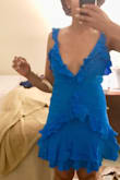 This dress is so adorable, it's adorned with ruffles from the shoulders down to the hem making it completely wedding guest or date night worthy, yet it still offers the slightest sexy feel by adding elements such as the low cut neckline and an opening in the back where it's tied above the zipper.  
It's a great buy!!! 
P.S. I'll update photos once I actually have it steamed & wear it out. - Noelle B.
