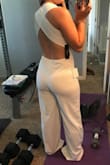 This jumpsuit is perfect for my bachelorette party in San Diego next month. The white fabric is thick and not see-through at all. It's boob-y, but tasteful and will definitely keep the girls in well thanks to the crisscrossed back. It will definitely need to be hemmed; I don't think I've ever worn something so long before. The back is stretchy-no zipper. That part on me could probably be tighter, and the hip and thigh region could be looser, but it's fine. It will be great! - Caitlyn N.
