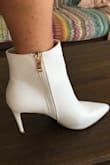I really wanted a pair of these white boots as they are on trend but didn't want to spend a fortune on a trendy item. I got these with the 15% off. I was nervous because I am 5' 0" and 105lbs and have scrawny ankles so I was afraid they would be too boxy or loose fitting around the ankle especially since the picture doesn't show how they fit around the top of the ankle. Thought they might be trying to hide the fact that they aren't very flattering. Well....that isn't the case at all. I am very pleased with them! They fit perfectly and are comfortable. I highly recommend. The gold zipper pull is attractive as well. - Pamela S.