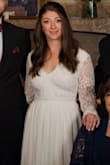 I ordered a large but had it tailored to more of a medium. I also added a slit on the side up to my knee, and I added a bow on the back which I loved! 
The hem was taken up and the chest area brought in to fit me perfectly. I only wore pasties and I think it looked fine. The sleeves fit well so I didn't touch them, which is great because my arms are a bit bigger in proportion to the rest of my body. The skirt has 3 layers which made it really feel like a good quality gown. 
My only negative is the waist band has zero stretch, which doesn't help during dinner hahah. If you get it tailored make sure to request some wiggle room for it. All in all it is a great deal for the price. I have been waiting for a year to write this review and am excited to finally share my own pictures! - Christina B.