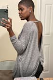 The top is a little oversized but I love the fit! When I washed it, I did read that it will shred and it did around the sleeve but your can trim it with scissors and it will be like new again. Overall, it's a nice sweater. Oh, and I wore an adhesive strapless backless bra.. will wear it with a bralette next time. - Samantha F.