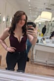 Absolutely loooove this bodysuit. Looks great, nice thick material, and boning in the V cut out. Definitely need a plunge bra or fashion tape with it but you can easily cut out a v in the tape. Straps are thick enough to hide plunge bra straps. Definitely low cut and I kinda wish I could adjust the straps, but definitely one of my fav bodysuits ever. - Taylor D.