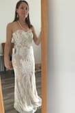 I absolutely love this dress! The ivory overlay glows on top of the nude under layer. The dress cut is incredibly flattering and makes me look like I have more of a waist than I really do. The top stays in place and feels very secure when moving. The dress is tight against the body, but looks great in photos and video. I am wearing 4" heels in this photo and am only 5' and the dress just hits the ground. - Cara J.