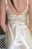 I wanted to love this dress! I thought it would be perfect for what I wanted, but the fit was strange in the back. The top fit perfectly, but the skirt bunched up weird in the back by the zipper, it was like it was sewn wrong. Not sure if it was suppose to be like that or not, but I'm returning it simply because my mom doesn't want to pay for something that didn't fit right haha. Other than that, it's a pretty dress! The color is more yellow than gold in person, and the material is thicker than I expected, which is good! I'm also wearing heels in the picture! - Faith E.