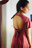 When I first got this dress, I loved it. The "rusty rose" color and the cut out back are lovely, and the material is comfortable and high quality.  It does wrinkle easily - even just sitting down will leave wrinkles - but luckily they come out completely with my steamer. 

After the first wear, however, I noticed a stain, so I gently hand washed the dress in cool water with about 1 tablespoon of detergent before leaving it out to air dry. The dress shrunk significantly! Before washing, it hung loosely. Now about 1.5 inches of the slip underneath is now visible, and it looks more like a body-con dress. I'm disappointed that it's lost its original shape and lightness. 

The pictures I posted are before washing - Rachel W.
