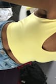 I just got this top and it's awesome. I'm not a big fan of crop tops, but this isn't extreme at all and feels pretty normal. The yellow is such a pretty shade. I was expecting the material to be synthetic, but its cotton. Also, the bottom of the top is a little tight getting in, but on it's perfect. - Violet B.