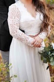 I absolutely LOVED it and got so many compliments! Like many other brides, we had to postpone our wedding but still wanted one kinda last minute! So I ordered this dress. I ordered a medium, altered the sleeves to fit my short arms and got a bit taken off the bottom! I also had them put in padding due to me having a smaller chest it fit looser. I also took it in on the top where it clasped together in the back. I recommend this dress!!! - Anna K.