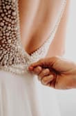 This dress was everything I wanted and more. I got married on the beach and it fit the part. I did have to get it hemmed so I didn't trip over it and I work a bra to do some smooshing. But people ranted and raved over it. It fits like a glove. I normally wear a small everywhere else except lulus I wear an XS. So go with either what you normally order or size down a little. Exchanges are so easy on here too. I've added photos to help out. And when I weighed a little more in still fit great. I added a close up shot of the back so you can see more detail. The beads are rhinestones and then little opal-y beads as well! - Michaela F.