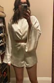 I have been looking at this romper for a really long time and finally bought it. I would say it fits a little big but I don't think I could size down to a 4. The length is perfect, not too long, not too short. Will look great with heels or OTK boots. The sleeves are really long and it's slightly big in the top at the shoulders. But not too bad. It's really pretty and high end. My husband loves it on me. - Angela L.