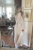 I am planning to get married in October so I thought a dress with long sleeves would be a good choice. This dress comes up high at the neck and the opening in the back is not super low, creating a very modest look and feel. The underneath is beige, but it makes the dress a pretty cream instead of stark white. It is form fitting, but stretchy so it doesn't feel tight. For the price, this dress is really great. I think the dress looks inexpensive, which is not necessarily a bad thing, but it is very soft and lightweight. I plan to dress it up even more with a pretty veil and hair piece. The only concern I have is what to do when it comes time to dance at the reception because it is a very long dress and there's nothing to pin the train up with. - Suzanna W.