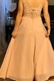 This dress is absolutely perfect for my best friend's wedding. It's simple, but elegant and sexy without pulling focus from the bride! It's truly soft pink (PANTONE  12-1209 TPX) the exact color. It runs true to size and fits like a glove! I did have the dress hemmed to fit with 4 inch heels and it floats beautifully with every step. The boning in the front is not obvious and really helps everything up top look  great. This will be a backless bra dress and seamless underwear are a must! I wore nude ones for the photo to demonstrate how sheer it is. The back is beautiful and the button detailing hides the easy to access zipper. I absolutely love this dress and you will too! - Valerie D.