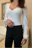 This is the kind of bodysuit you can wear to a fancy event. The sleeves are absolutely gorgeous, and are much more flowy than I've seen on other pieces like this one. It fits perfectly, so definitely order your size - no bigger, no smaller. It's elegant and right around the waist, and the bottom part where it buttons up doesn't cause any discomfort. Plus it doesn't show, even with thin/tight pants! The quality of it is also immaculate. Not to mention, it feels smooth on the skin. The material is something you'd want to sleep in. Very pleased with the purchase, I'll be ordering it in other colors as well. I know this bodysuit will last a while and be an absolute banger at events! - Rebeka K.