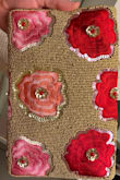 I agree with the reviewer who said the back of the clutch has the allover flowers. I was looking forward to the single flower, as shown in the listing. I am keeping it though because I got it for a wedding I need a clutch for in 2 days so it certainly fits the bill. It is cute/colorful and springy. Don't know yet how long the beads will stay on. But other than the difference in the back of the purse, I am happy with the purchase considering the price. The second photo shows the back (no fold over). - Caroline B.