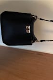 I was back and forth about purchasing it for a little while but I'm so glad I did! I love how sleek it looks and the little phone pocket on the back. The only downside and the reason I didn't give 5 stars is because on the loop to connect the strap the gold looked like it was peeling off some. Overall it is a great beautiful bag! - Sarah M.