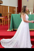 This dress fits true to size and has stretchy material for us curvy girls! There are multiple layers and has a delicate lace train which looks beautiful fanned out. V neck was an appropriate depth and had enough room to wear a regular bra. Definitely needed to be hemmed even with my 3 inch heels, but ordered this 4 days before my wedding since it came back in stock last minute. Will definitely order from Lulus again! Thanks for a beautiful wedding dress! - Leann V.